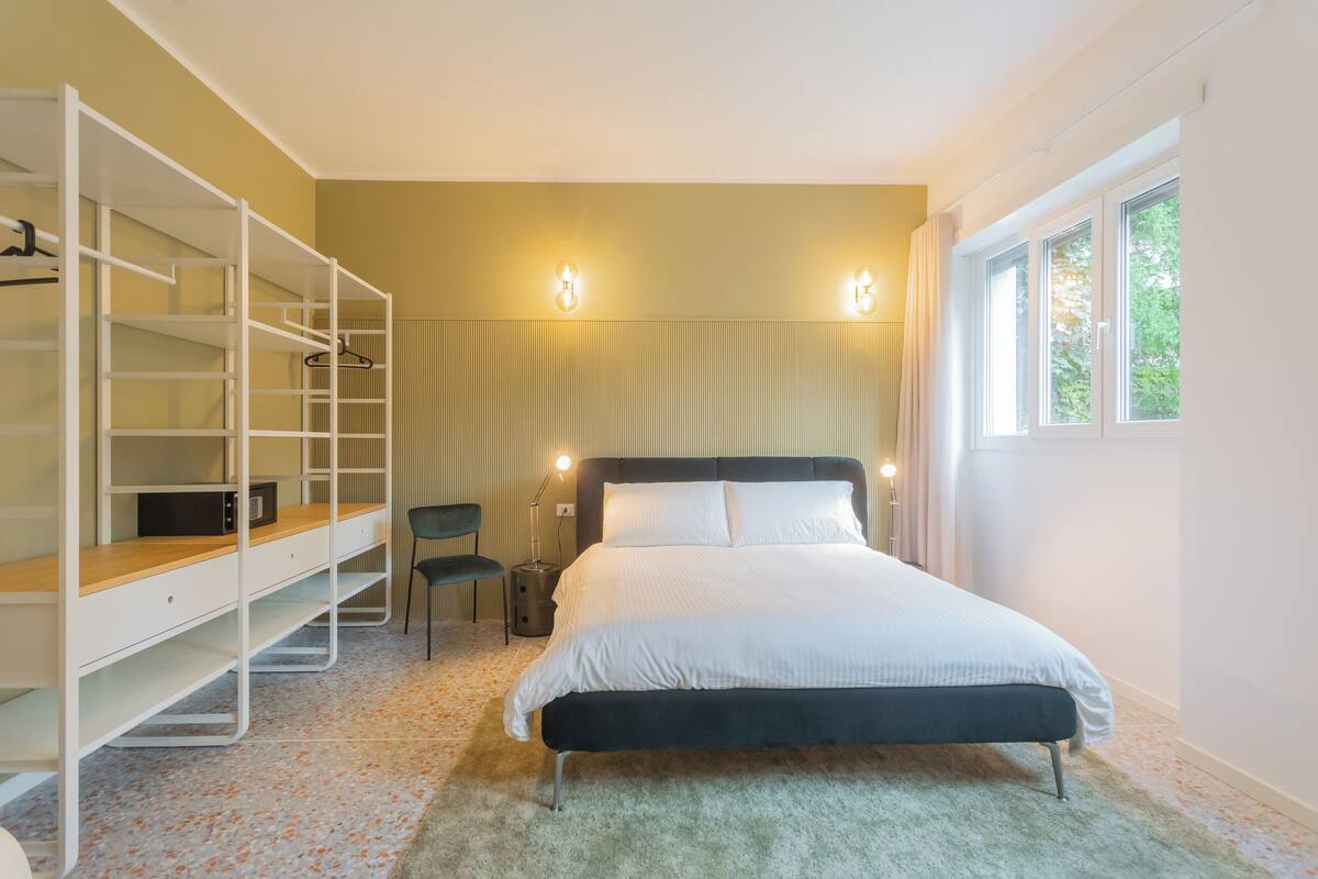 Une chambre à coucher comprenant un lit, une armoire avec des étagères, un bureau et une chaise.
