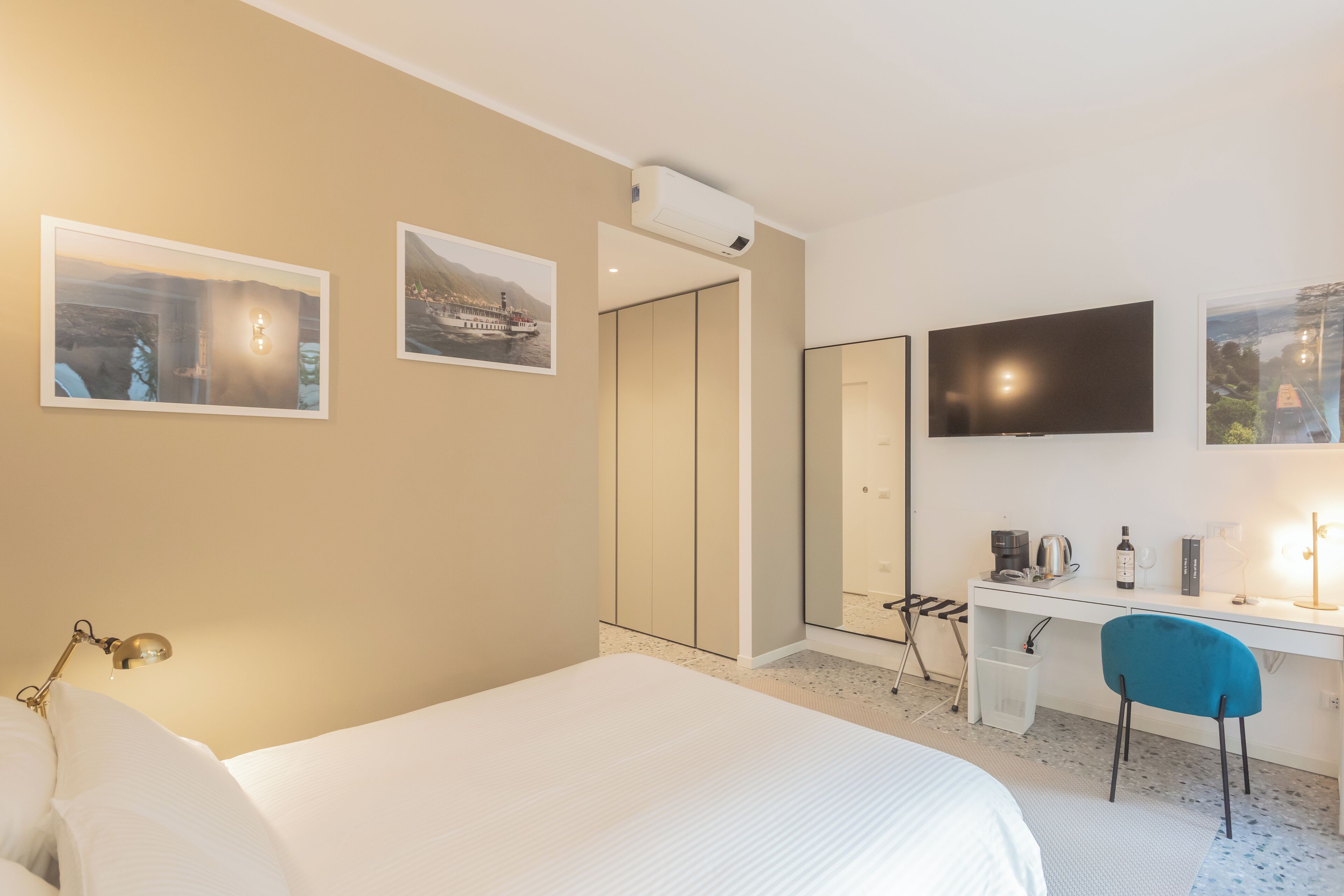 Een hotelkamer met een bed, een bureau, een stoel, een televisie en een kledingkast.