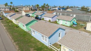 A row of single-story mobile homes with flat roofs, arranged in a linear fashion along a street.