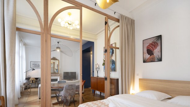 Une chambre d’hôtel avec un lit, un bureau avec un ordinateur, une chaise et un miroir.