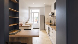 Une cuisine moderne avec un îlot central en bois, des meubles blancs et un four encastré.
