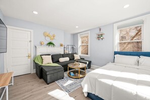 A modern bedroom with a bed, a sofa, a coffee table, and a desk. - Cozy Apt in Center City Very Central Location (Philadelphia)