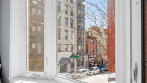 A view from a window overlooking a street with buildings, a street sign for Cypress Street, and parked cars. - Cozy Apt in Center City Very Central Location (Philadelphia)