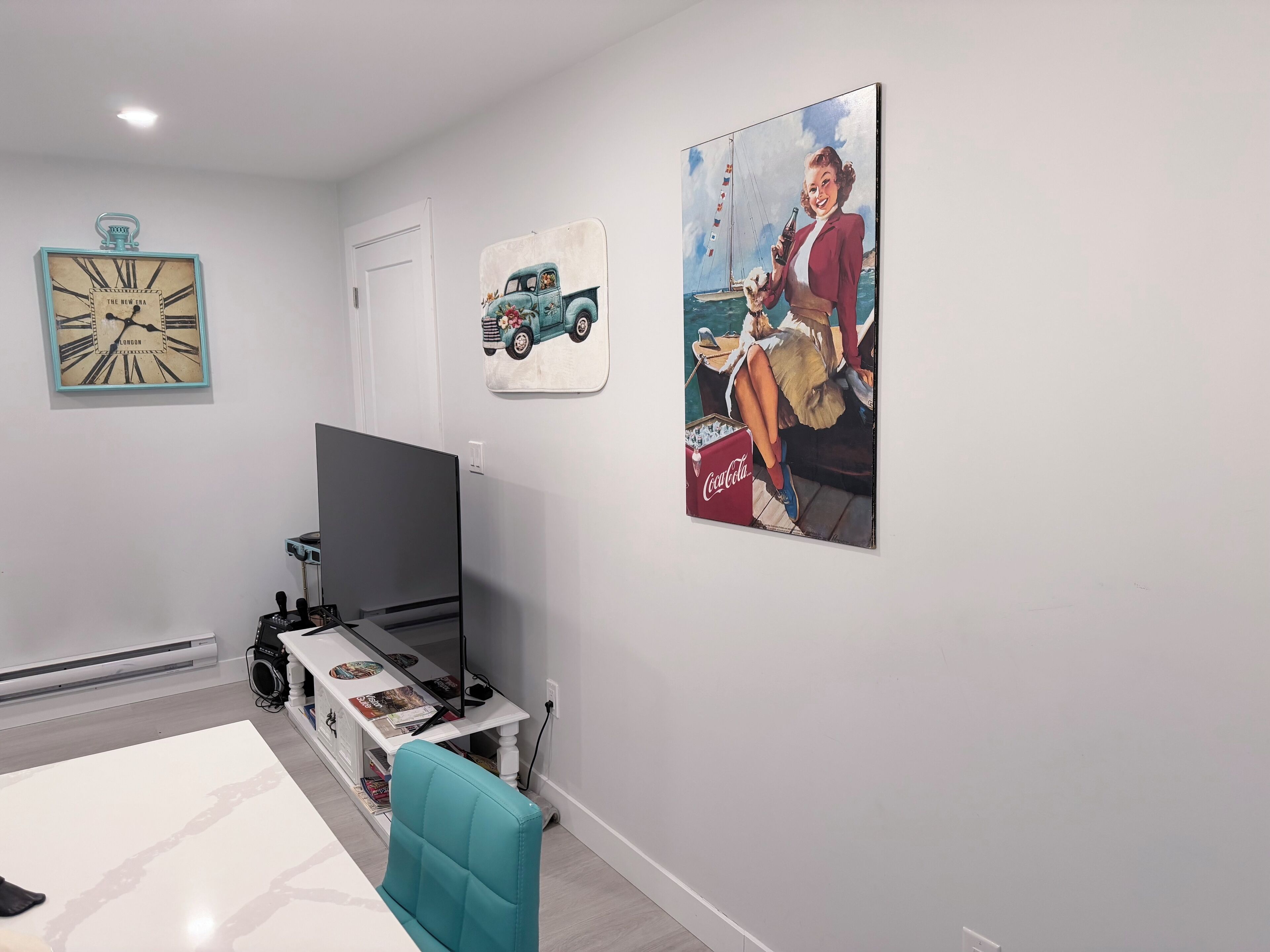 A modern living room with a flat-screen TV, a sofa, a coffee table, and a bookshelf.