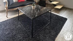 A modern living room with a black leather sofa, a glass coffee table, a wooden staircase, and a window with a view of the outdoors. - la Mine - Saint-martin-du-fresne (SAINT-MARTIN-DU-FRESNE)