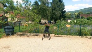 A garden area with a chair, a fence, and a sign that reads 'Garden.'