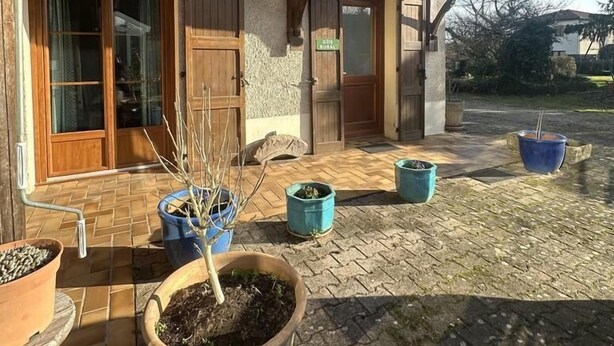 A two-story house with wooden shutters, a tiled patio, and potted plants. - G424020 - Tramoyes - Gîte (TRAMOYES)