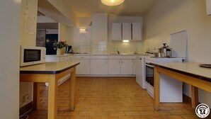 A compact kitchen with white cabinets, a microwave, a sink, and a stove.