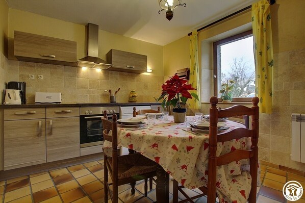 Enjoy cooking and dining in this well-equipped kitchen with a stove, oven, and range hood, perfect for meals with family and friends.