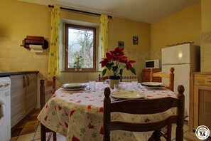 Enjoy meals in this kitchen with a dining area, featuring a refrigerator, microwave, and cabinet.