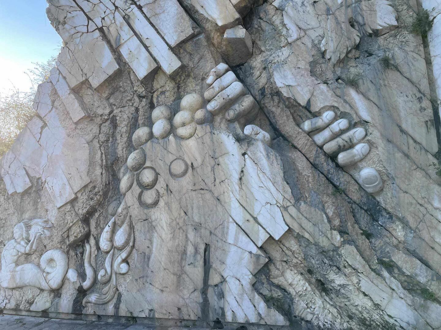 A rock wall with carved figures and patterns.
