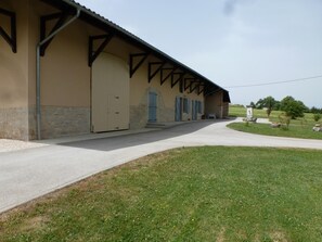 A building with a beige exterior, a stone base, and a metal roof.