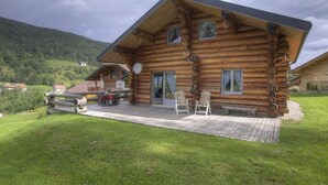 A log cabin with a deck, two windows, and a satellite dish. - Chalet La Fuste Monts Jura (LELEX)