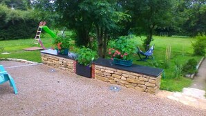 A garden area with a stone wall, a ladder, and potted plants. - des Grands Cours - Marboz (MARBOZ)