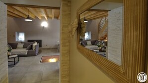 A spacious living area with a sofa, a coffee table, and a mirror. - des Grands Cours - Marboz (MARBOZ)