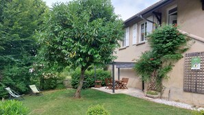 A well-maintained garden with a patio area, outdoor seating, and a pergola. - la Grande Fontaine - Ceyzeriat (CEYZERIAT)