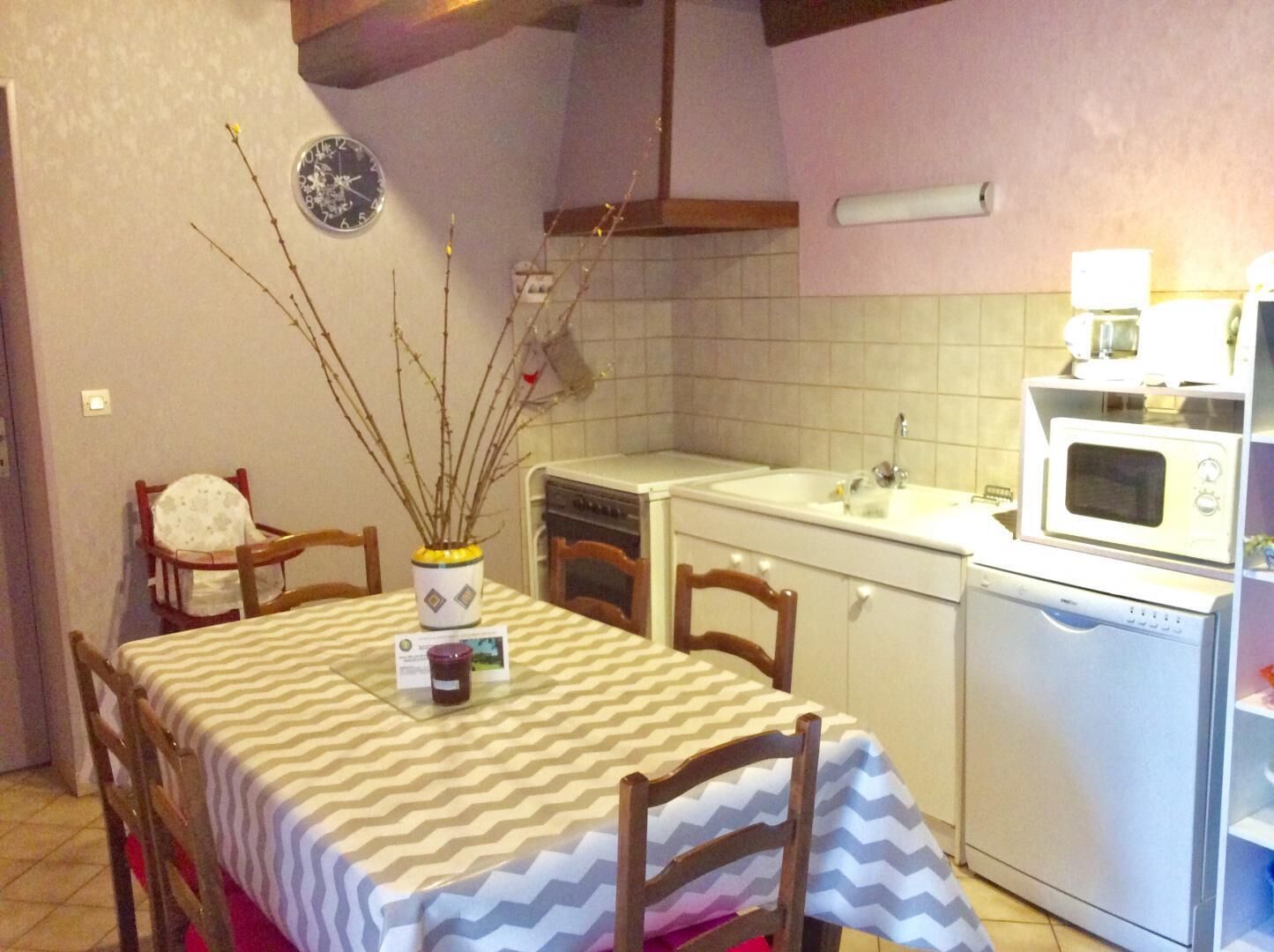 Una cucina compatta con angolo ristoro. Include un forno a microonde, lavello e un piccolo frigorifero.