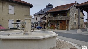 Ein Steinkonnt in einem Stadtplatz mit traditioneller Bebauung im Hintergrund.