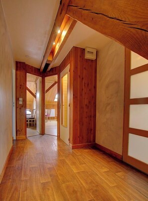 Un intérieur en bois avec un plafond haut et une boîte électrique apparente.