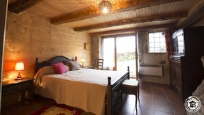 Une pièce en bois avec un lit, une table de chevet, une lampe, une fenêtre et un radiateur.