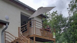 A multi-level outdoor staircase with a metal railing, a potted plant, and a picnic table in the background. - Gîte du Buizin - Vaux-en-bugey (VAUX-EN-BUGEY)