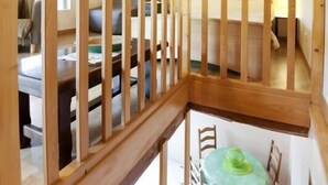 A wooden staircase with a railing leading to a lower level.