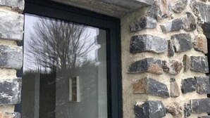 A stone building with a large glass window and a stone number '4' above it. - Beaume d’ataraxie - Beautiful View Room (Apt. 4) (Solignac-sur-Loire)