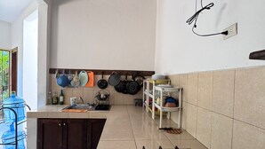 Eine Küche mit Gasherd, Spüle und Wandventilator.