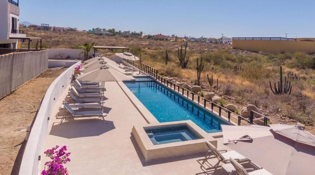 Ein Poolbereich mit Liegestühlen, einem kleinen Pool und einer Wüstenlandschaft im Hintergrund.