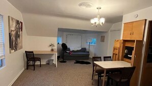 A compact living space with a dining area, a sofa, and a small kitchen area. - 418 W. Main, Apartment #4.

 (Luverne)