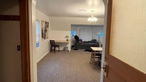 A hallway leading to a living area with a dining table, chairs, and a sofa. - 418 W. Main, Apartment #4.

 (Luverne)