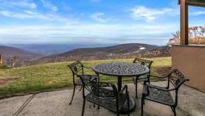 An outdoor patio with a round table and four chairs, overlooking a mountainous landscape. - Cliffs 21 with Wintergreen Advantage (Wintergreen)