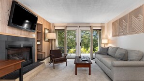 A modern living room with a fireplace, a flat-screen TV, a sofa, and a coffee table. - Stoneridge 43 with Wintergreen Advantage (Wintergreen)