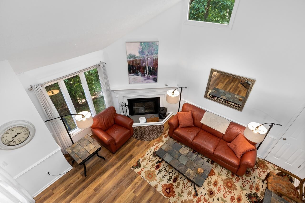 A living room with a fireplace, two leather sofas, a coffee table, and a patterned rug.
