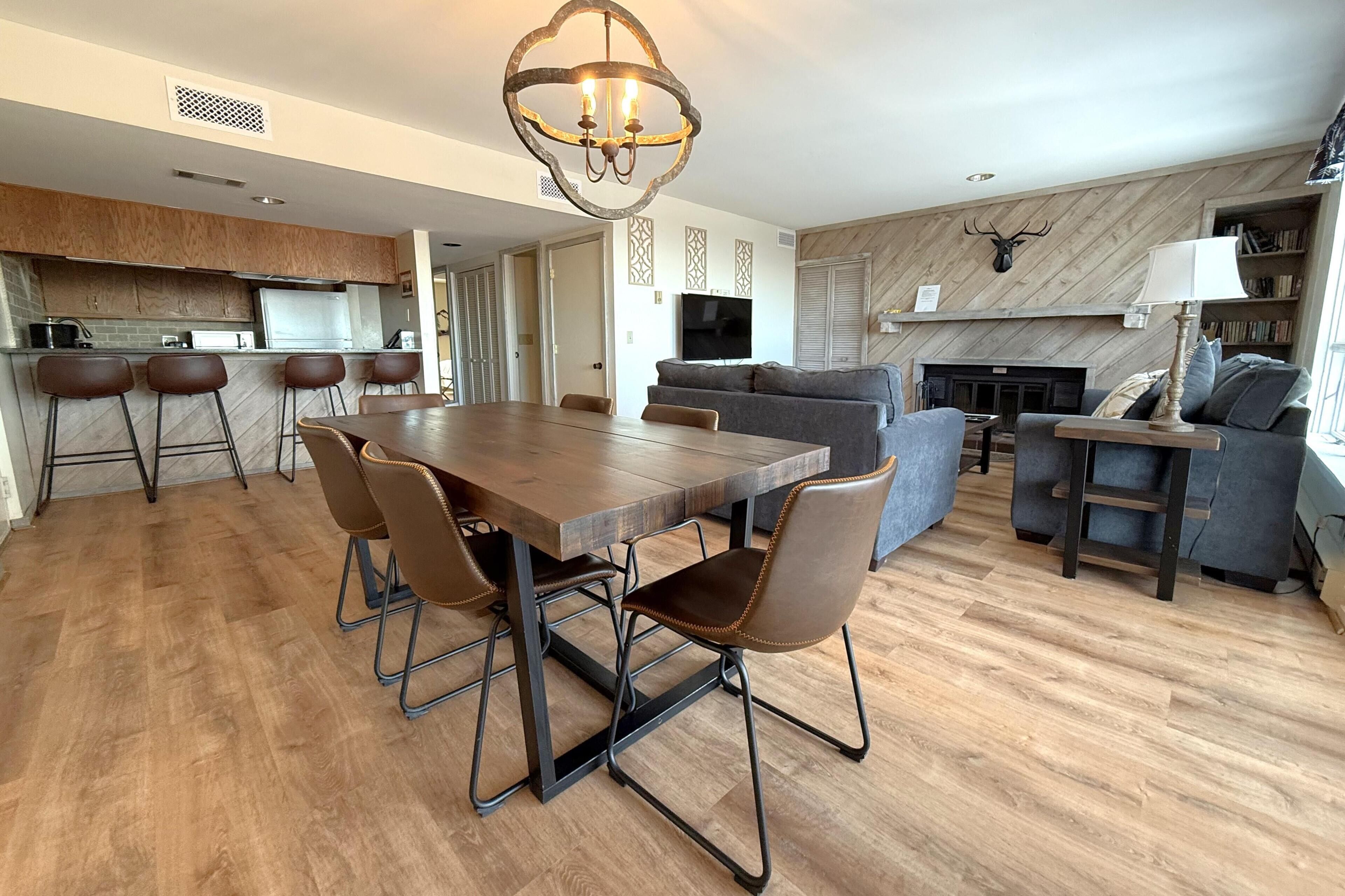 A modern living space with a dining area, kitchen, and seating area.