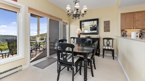 A dining area with a table and chairs, a chandelier, and a view through a sliding glass door. - Overlook 43 with Wintergreen Advantage (Wintergreen)