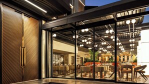 A modern interior with a bar area, seating, and a glass entrance. - Boreas Hotel & SPA, Trademark Collection by Wyndham (Ankara)