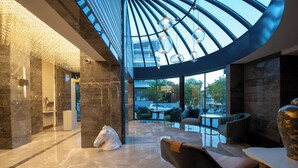 A modern interior with a glass ceiling, marble flooring, and contemporary furniture. - Boreas Hotel & SPA, Trademark Collection by Wyndham (Ankara)