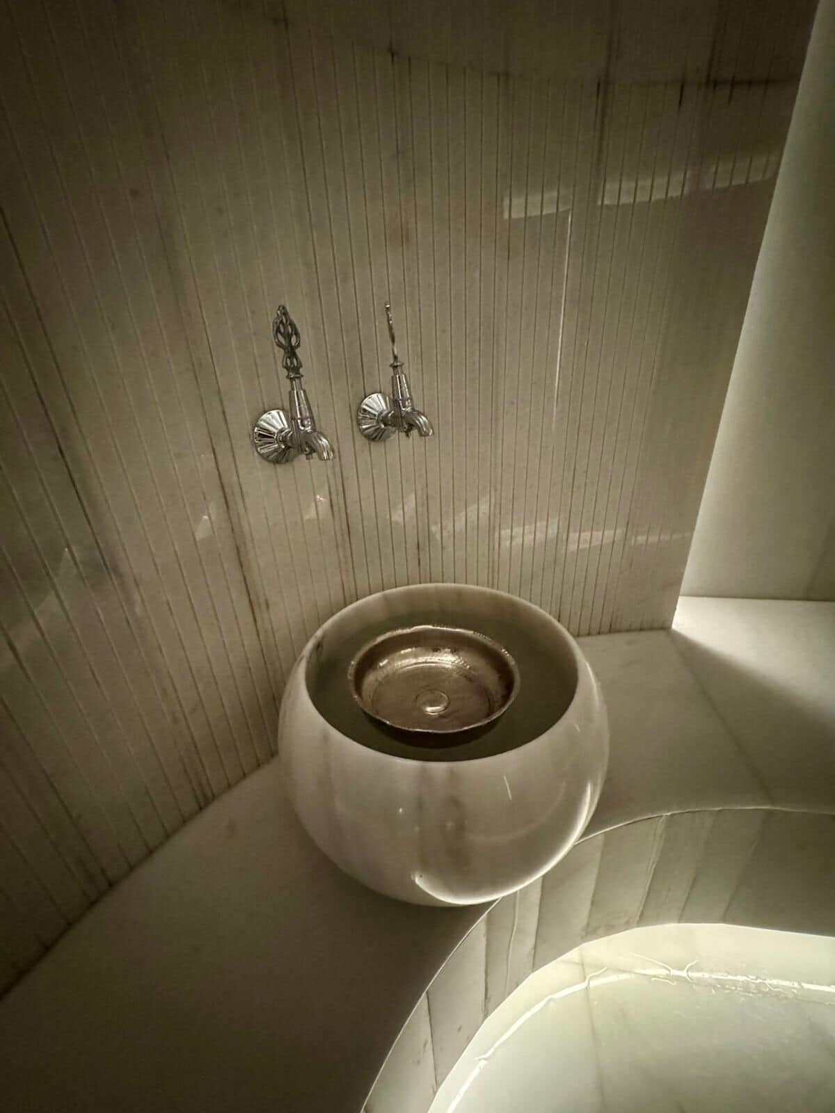 A bathroom with a white sink, a mirror, and a towel rack.