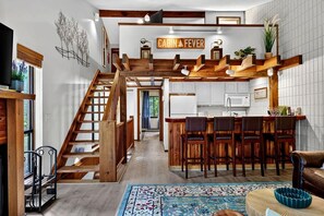A cabin interior with a wooden staircase, a kitchen with white cabinets, and a bar area. - White Oak 46 with Wintergreen Advantage (Wintergreen)