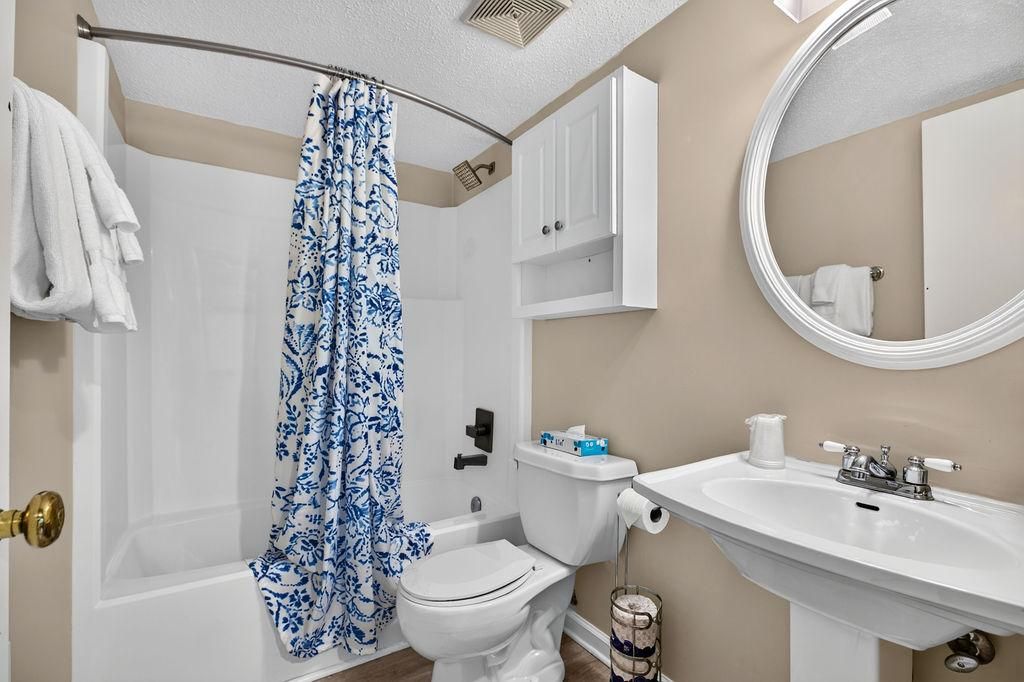 A bathroom with a bathtub, toilet, and sink.