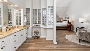 Un dormitorio moderno con una cama grande, una mesita de noche con lámpara y vistas al salón.