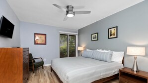 A bedroom with a bed, a desk, a chair, a TV, and a ceiling fan. - Stoneridge 69 with Wintergreen Advantage (Wintergreen)