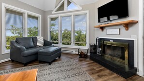 A modern living room with a sectional sofa, a fireplace, and large windows with blinds. - Shenandoah Ridge 07 with Wintergreen Advantage (Wintergreen)
