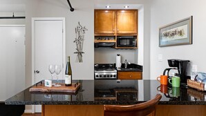 Une cuisine moderne dotée de meubles en bois, d’une cuisinière à gaz, d’un four à micro-ondes et d’une machine à café.