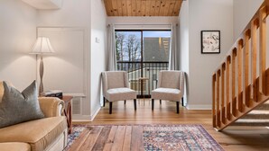 A living room with a wooden ceiling, a sofa, two armchairs, a lamp, a patterned rug, and a staircase. - Mountain Inn Lodge 59 with Wintergreen Advantage (Wintergreen)
