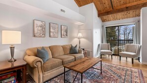 A cozy living room with a wooden ceiling, a beige sofa, two armchairs, a coffee table, and a patterned rug. - Mountain Inn Lodge 59 with Wintergreen Advantage (Wintergreen)