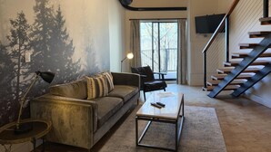 A living room with a sofa, coffee table, and a staircase. - Mountain Inn Lodge 70 with Wintergreen Advantage (Wintergreen)