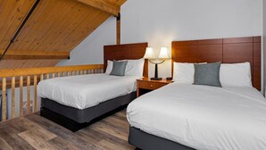 A room with two beds, wooden headboards, and a sloped ceiling. - Mountain Inn Lodge 83 with Wintergreen Advantage (Wintergreen)