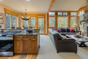 A spacious kitchen with wooden cabinets, a large island, and a dining area with a sofa and table. - Stunning Townhome with Great Views (Keystone)
